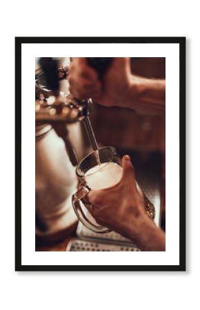 Barman filling glass with lager beer in pub