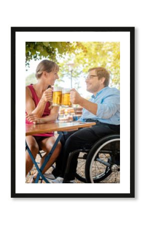 Disabled man in wheelchair and friend drinking beer