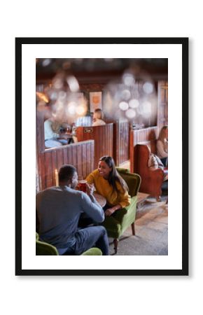 Couple Meeting For Lunchtime Drinks In Traditional English Pub Making A Toast