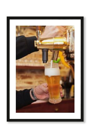 タップ（ビールサーバー）からグラスにビールと泡をなみなみと注ぐシーン　パブ