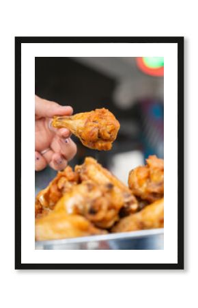 Hand holding a crispy fried chicken wing