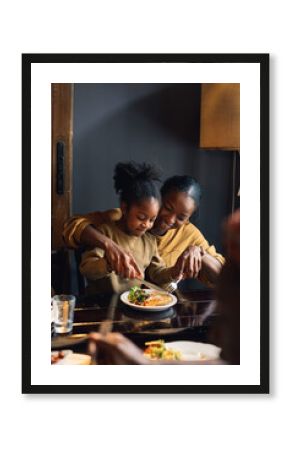 A Mother Helping Her Daughter with Food in a Restaurant