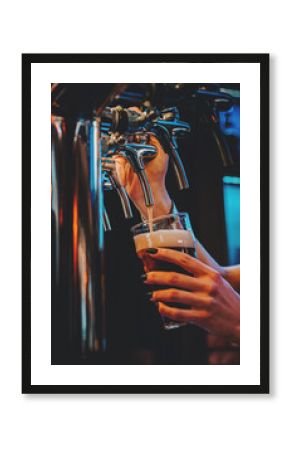 woman bartender hand at beer tap pouring a draught beer in glass serving in a restaurant or pub