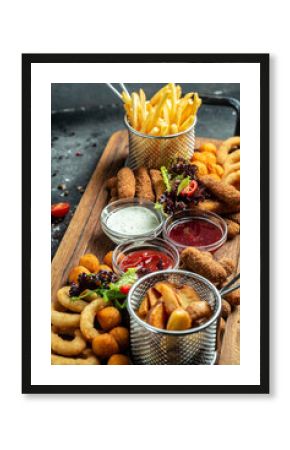 fast food meals mozzarella sticks, onion rings, french fries, chicken nuggets and sauce. pub appetizers on a wooden board. banner, menu, recipe