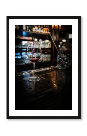 bartender hold red wine into a glass in cafe or bar