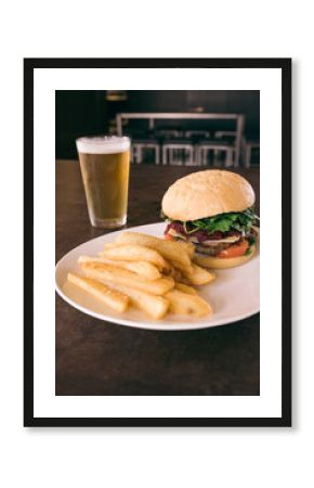 aussie burger with beetroot on plate with chips and a beer