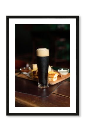 Still life of Glass of stout beer on pub table