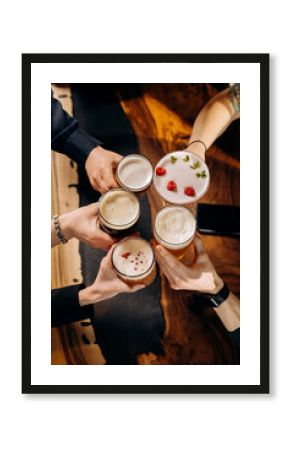 Friends hands toasting and having fun together drinking beer and cocktails at happy hour in pub restaurant . Social life style party time concept