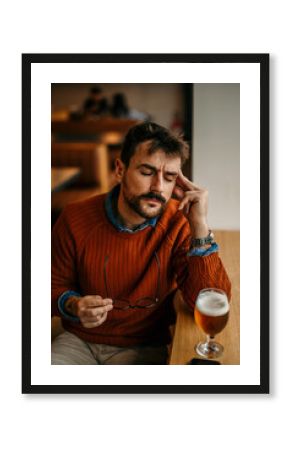 Man sitting in the pub and having a beer.