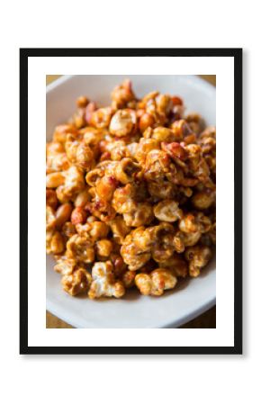 close up of caramelized peanut popcorn on a white bowl 