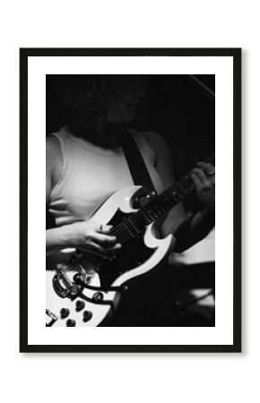 female musician playing guitar band at a rock show to an audience watching. sound check with a switcher in a music venue