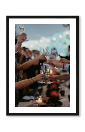 BRINDIS DE VARIAS COPAS DE CHAMPAN, MANOS DE HOMBRES Y MUJERES SUJETANDO LAS COPAS
