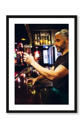 Waiter pouring whiskey in an Irish pub