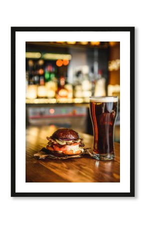 Hamburger and dark beer on a pub background.