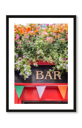 Bar sign with flowers and irish flag colors, irish pub concept in Dublin, Ireland