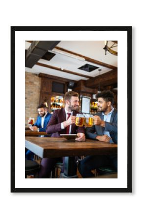 People, friendship and celebration concept. Happy business male friends drinking beer at pub