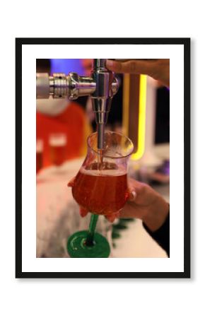 barman llenando una copa de cerveza desde el grifo de cerveza de la barra del bar