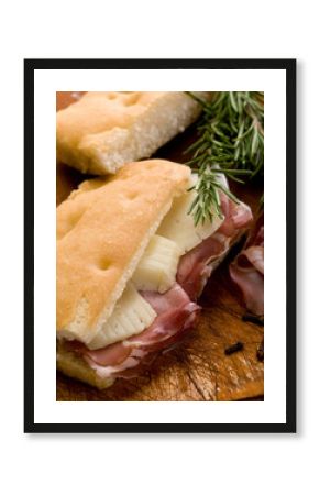 focaccia with speck and cheese over cutting board