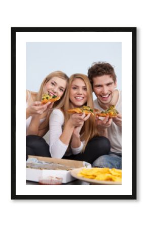 Group of young people eating pizza at home
