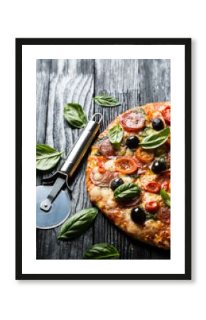 Pizza with salami, olives and basil