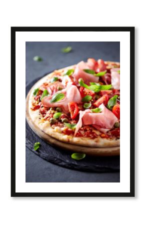 Pizza topped with black forest ham, capers and tomatoes    