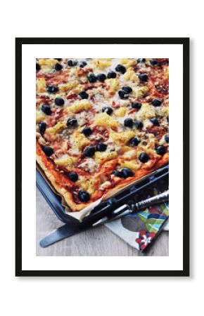 Homemade pizza with pepperoni, olives, oregano, pineapple, tomato sauce and cheese