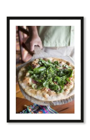 Pizza being served on a wooden board
