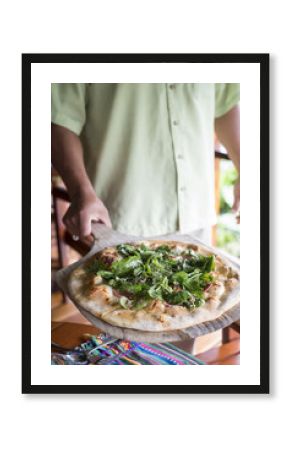 Man serving pizza on a pizza board