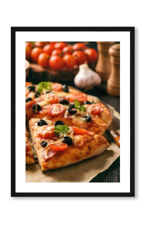 Homemade pizza with ham, cheese, tomatoes and olives.