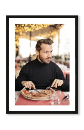 Handsome man eating a pizza