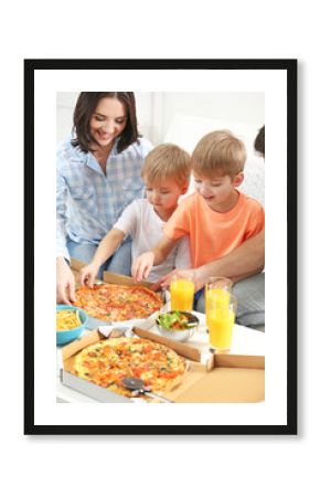 Happy family eating pizza on sofa all together
