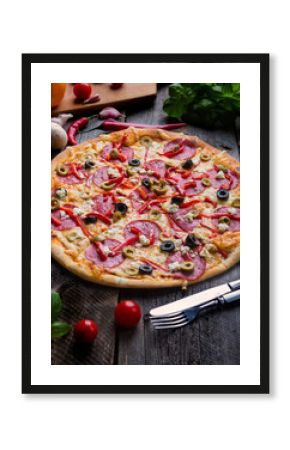 Freshly baked pizza with feta cheese, olives, salami and paprika