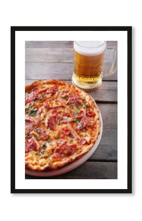 Tasty pizza and glass of beer are on wooden table, close up