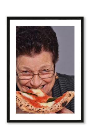 señora anciana comiendo pizza.