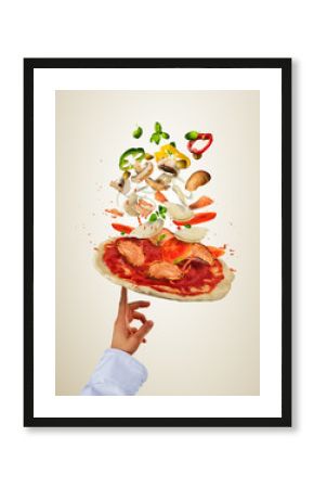 Chef preparing pizza with flying ingredients