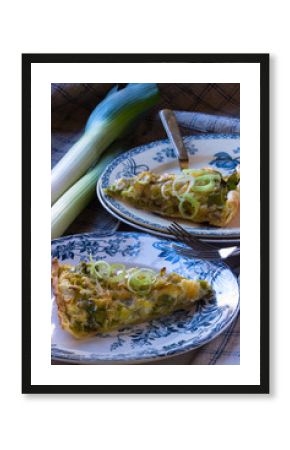 Ein Stück Lauchkuchen vegetarisch auf einem anitken Französischem Teller angerichtet