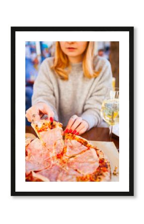 Italian food dinner. Woman eating Pizza with tomato prosciutto mozzarella glass white wine summer outdoor restaurant