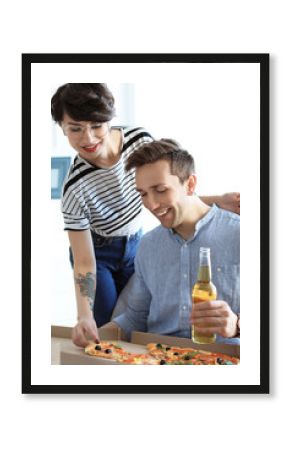 Young couple eating delicious pizza indoors