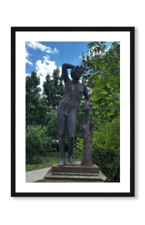 metal statue of a naked man in the park