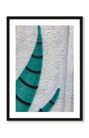 A close-up teal and black striped plant graffiti on a textured white wall, urban street-art background texture