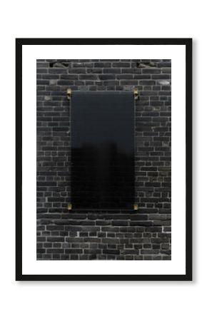 Blank board mounted on a dark brick wall offers a canvas for messages, set against the urban texture of bricks.