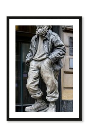 A stone statue of a man in a jacket and