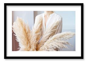 Woman in White Blouse Holding Pampas Grass. Lifestyle.Reed Plume Stem, Dried Pampas Grass, Decorative Feather Plant Arrangement for Home, Trendy Home Decor.