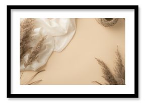 Top view photo of white light scarf spool of twine and reed flowers on isolated beige background with copyspace