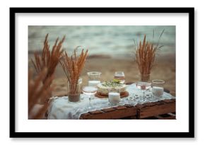 picnic in the evening at sunset on the sandy shore of the sea or ocean. decor in boho and rustic style.