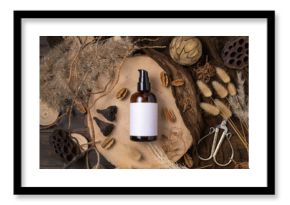 Cosmetic one pump bottle on wood near natural boho decorations top view. Label Mockup
