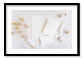 Blank cards near silk ribbons and dried hare's tail grass top view on white, boho mockup