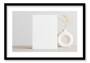 White invitation card mockup with a gypsophila on the beige table. 5x7 ratio, similar to A6, A5.