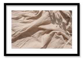 Abstract neutral background, crumpled draped linen fabric texture on sun light with soft shadows, aesthetic sustainable bohemian backdrop, copy space