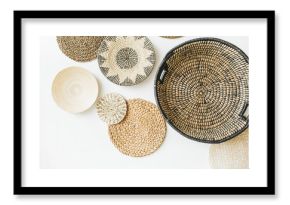 Decorative straw plates on white wall.